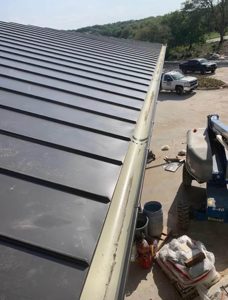 Standing seam panel and gutter detail on a metal roofing jobsite in Midland